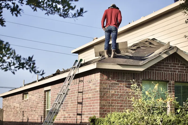 Professional roofer working on a residential roof in Lake Angelus